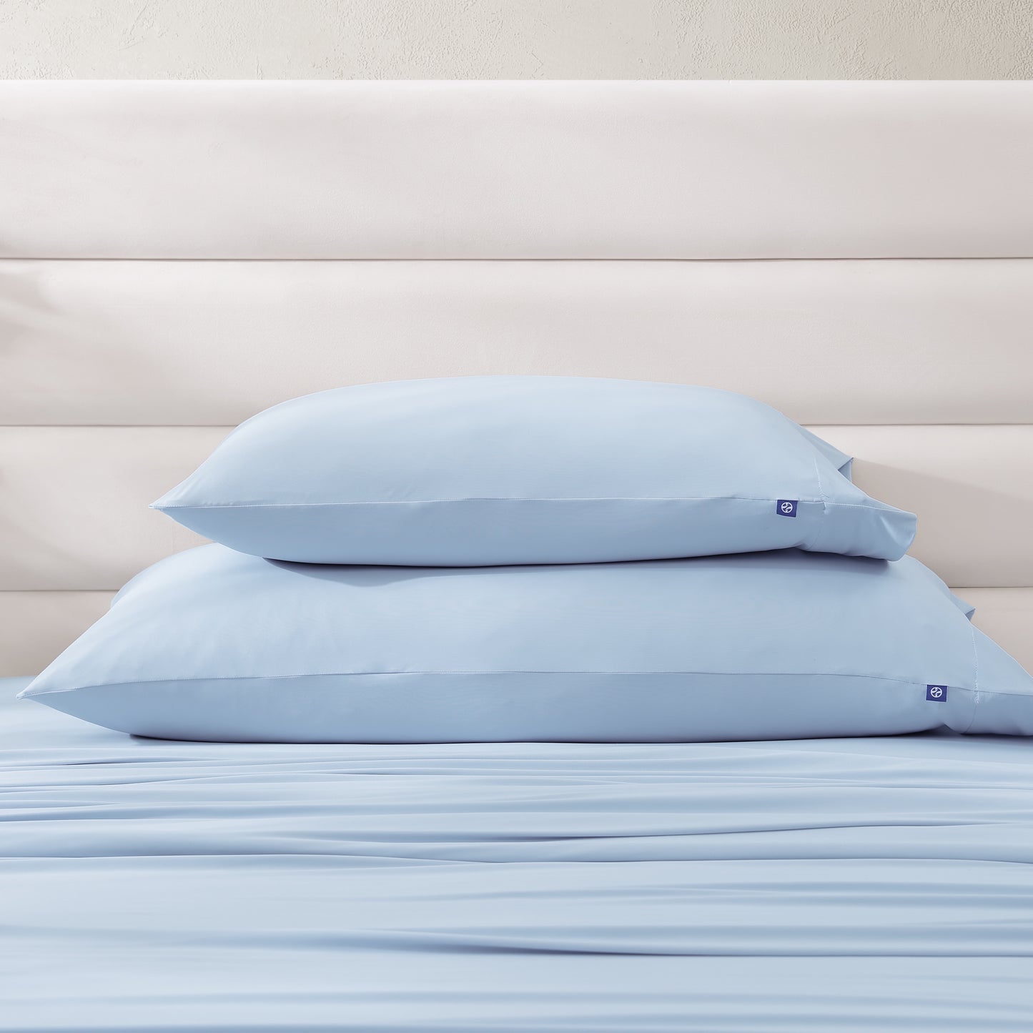 Stack of standard and king cooling pillowcases in light blue, part of sheet set collection.